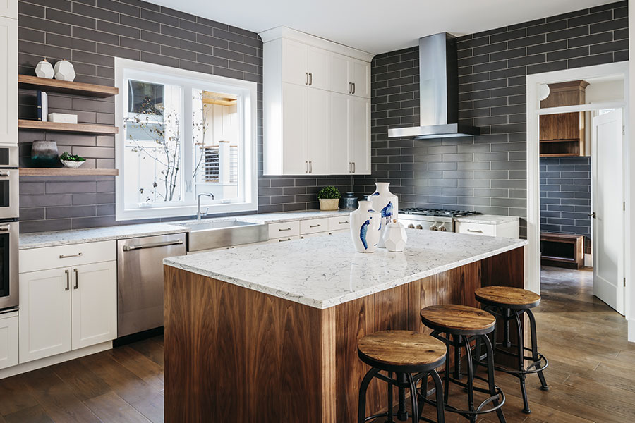 kitchen-with-black-tile-walls-and-wooden-island-with-marble-top-melba-id